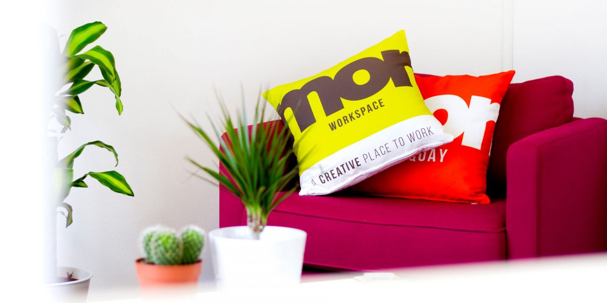 Pink sofa with Mor Branded cushions and plants on table